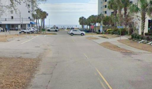 View of asphalt street featuring traffic signs