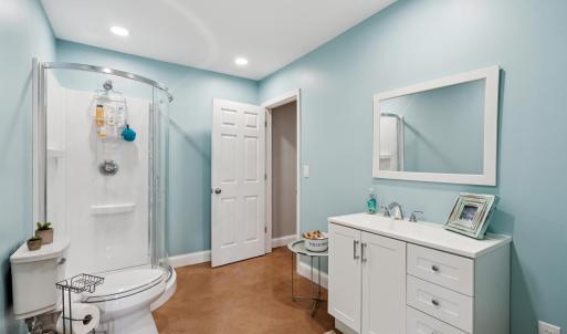 Full bath with finished concrete floors, vanity, a