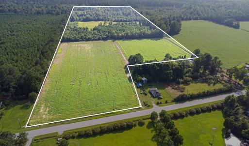 View of rural area featuring a forest and property