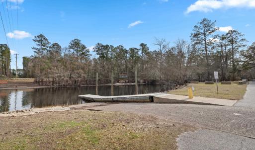 View of yard with a boat ramp, a dock, and a water