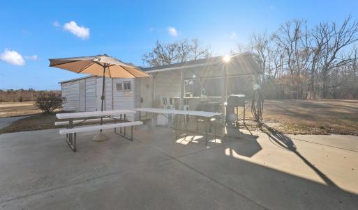 View of patio featuring an outbuilding, a sunroom,
