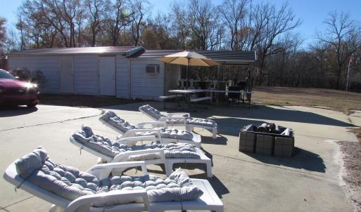 Large patio area with loungers, firepit and buildi