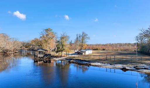 View from the river featuring a gazebo and a boat