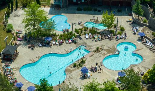 The expansive main recreation area by the General Store generally features three distinct water sections: a main swimming pool, a designated activity/kiddie pool, and an interactive splash pad for children.