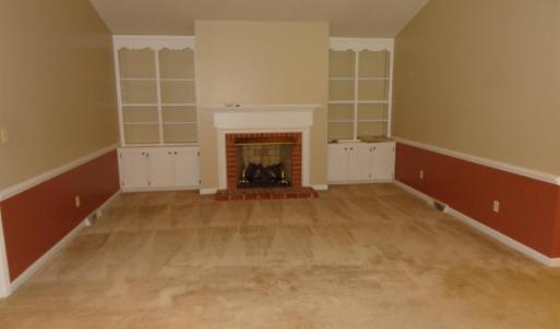 Great room with vaulted ceilings, brick gas log FP, built in bookshelves and cabinets on both sides of FP