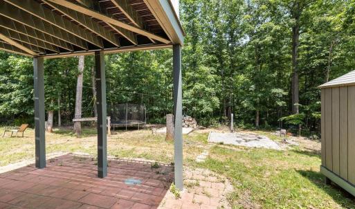 From the exterior downstairs door, you walk onto the brick patio under the upper deck ... ahead are all the fun activities! There is a zip line strong enough for adults to use! The trampoline can convey and it has been carefully leveled, the feet are buried 18" deep, new protective net, springs and bouncy floor. Straight ahead almost hidden is a real tree house! And sandbox, and pad for above ground pool with a wood heater for the pool! Don't forget a trail in the woods!