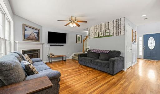 Living Room with gas fireplace. Front door in the background, door to basement on the L of wall, 1/2 bath opposite