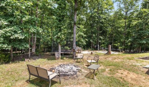 Overlooking the firepit from the deck. the tree stump in the background has towel racks if you choose to replace the above ground pool.