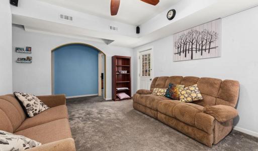 Family room downstairs. To the right of the blue wall is Bedroom 5. to the left is another full bath, a large storage room, and what another flex room with a closet but no window.