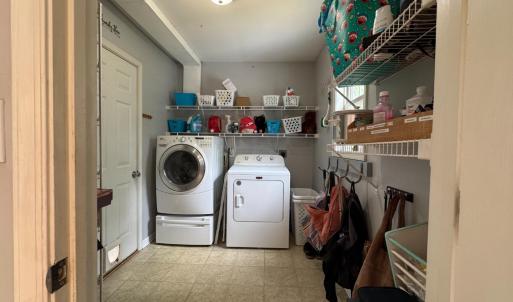 Laundry room with hooks for backpacks and shelves behind the door on left also. The door to the garage is here on the left.