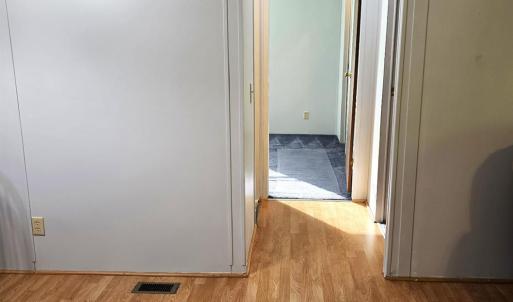 Hallway to the remaining two bedrooms and full bath