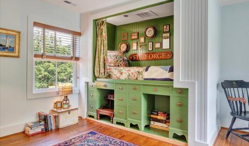 “Jefferson-style” curtained bunk sits atop two student desks taken from UVA Lawn.  Hidden storage underneath bed contains 8 boxes of all Christmas ornaments and other holiday accoutrements.  Storage area also contains back panel access to Grecian tub in bathroom.
