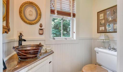 Copper bowl sink. Mirror original to house. “Appointments” found around property and brought in as “museum pieces”.