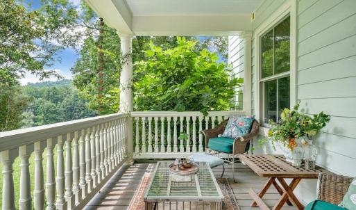 Front porch/veranda with some original furniture (including chicken coop table). “New” railings from Lynchburg mansion, completely restored.