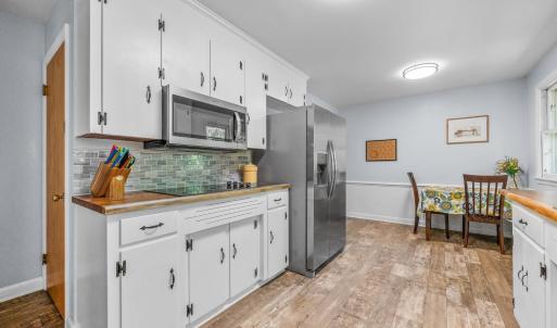 Kitchen with new countertops, backsplash, stovetop, and microwave