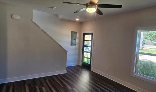 Living room showing 5 lite glass front door , stairs to 2nd floor and vinyl plank flooring