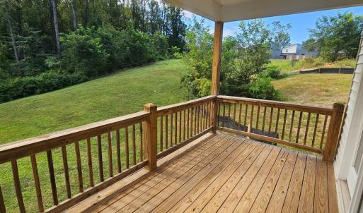Covered rear deck overlooks greenspace area