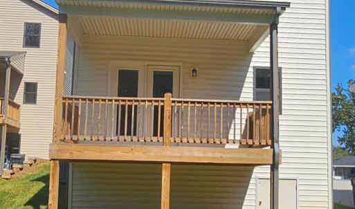 Rear of home showing covered deck with French doors from the formal DR and crawlspace door to bottom right