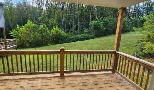 Covered rear deck overlooks greenspace area