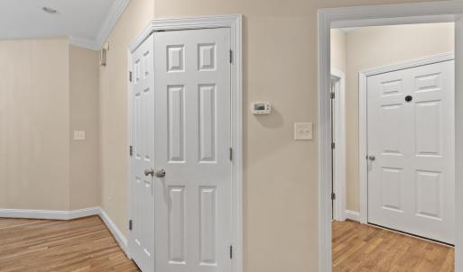 Hall closet looking towards main level full bathroom and garage