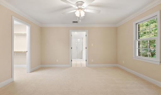 Large sitting room with walk-in closet to left and primary bathroom straight ahead