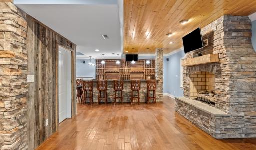 Beautiful stone gas fireplace with logs and tongue and groove ceiling