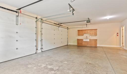 Oversized three car garage with sink and cabinet area