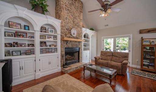 Greatroomshowing French door to deck, rock FP, arched built in display  shelves and cabinets