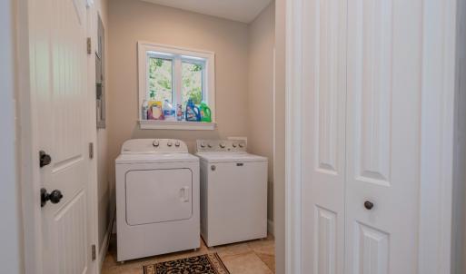 Laundry room in hallway from kitchen as well as half bath to right