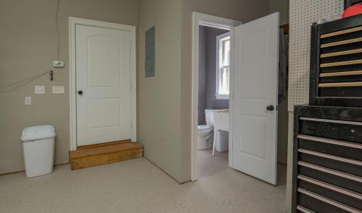 Garage showing half bath to right  , door to left goes through covered walkway to house