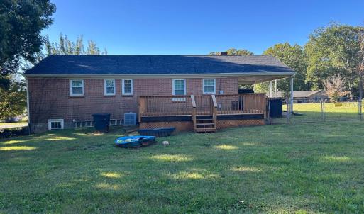 Deck built in 2024 leads out to level fenced backyard.