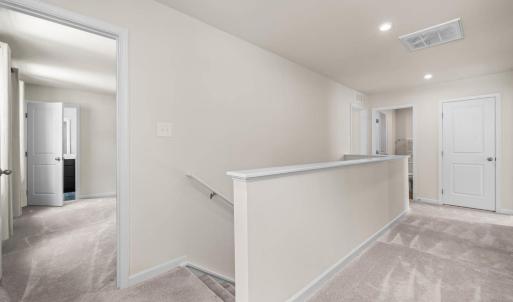 At the top of the stairs is the Primary suite.  The large linen closet is pictured here at the end of the hall.