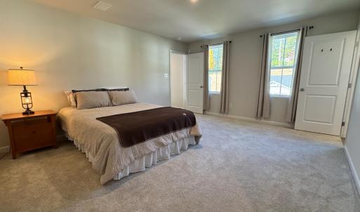 Two windows on the front of the house. The door on the right is the bathroom