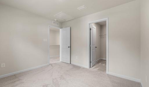 Bedroom 2 opposite Primary suite on the front of the house. The closet is a large lighted L-shqped walk in