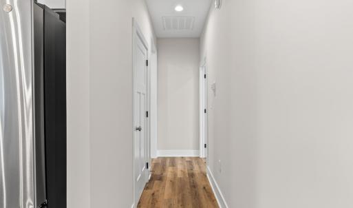 Hallway to Primary suite on right, large laundry room to left