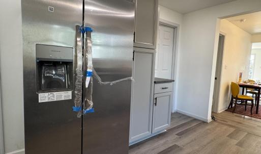 Lots of cabinets and great lighting! Left of the frig is the laundry room. The door on the right is the dowstairs full bath. Just past this wall is the door to the downstairs bedroom