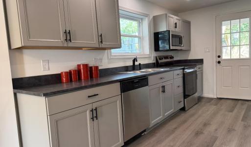 Appliances that convey: refrigerator, dishwasher, stove, microwave.  Back door opens to a patio with a large exterior storage closet and a deep back yard