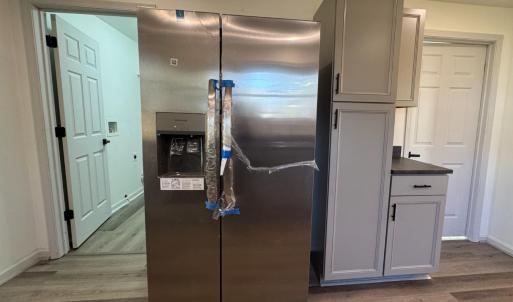 The refrigerator is on the opposite side from the sink. The laundry room on the left. The downstairs bathroom on the right