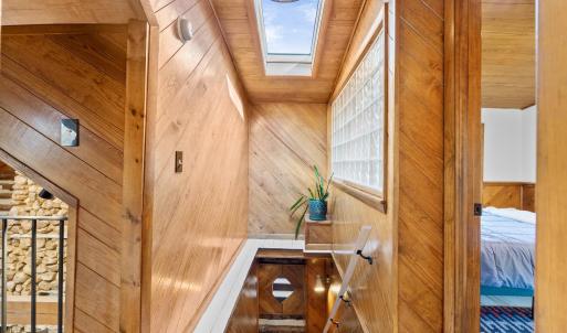 Stairway to Upper Level Featuring Sky Light & Glass Brick Wall