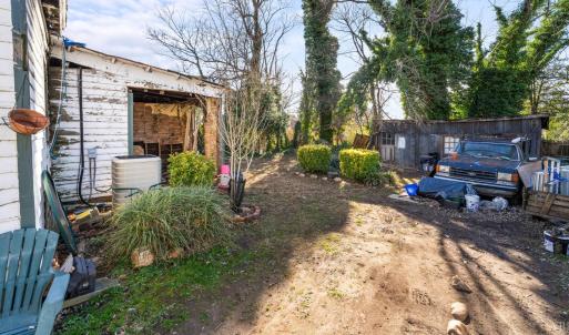 The room here with open sides under roof is where the plumbing and electric was brought to the exterior. It could be enclosed as a screen porch, finished as another room, or taken down. The lot is large! 60' wide by 132'deep. The detached workship is in the back.