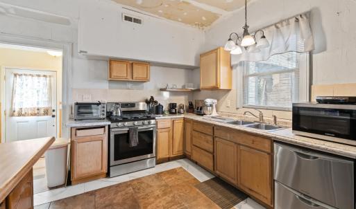 The exterior door in mudroom through doorway. Tile floor. The kitchen is on the back of the house. Appliances do not convey.