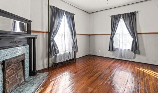 Room adjacent to the front room; better view of mantle and original tiles around firebox in this room.