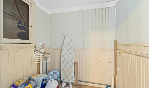 Main floor laundry room with original beadboard. At bottom right, see electric and plumbing leading to a room on the other side of the wall on the exterior