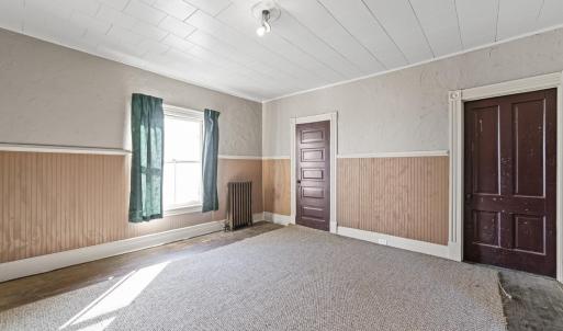 Bedroom 1 at the front of the hosue. The door by the window is a pass through to the room behind it on the back of the house. the door on the right is the closet.
