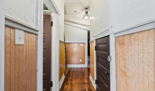 Door on left is the full bath. Door on right is storage closet with shelves under the stairs. Straight ahead is the hall to the back of the house.