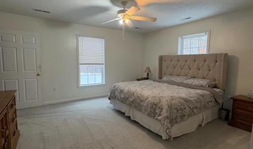 Primary main level bedroom with new carpet.  Has its own bath and walk in closet.