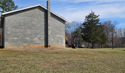 Side of garage with flue for woodstove.
