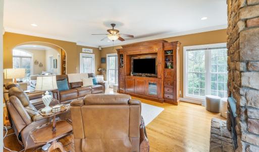 Family room with propane fireplace, tall ceilings, crown molding, surround sound, hardwood floor, arched entry ways and plenty of windows! The beautiful veranda/side porch entry is off of the family room.