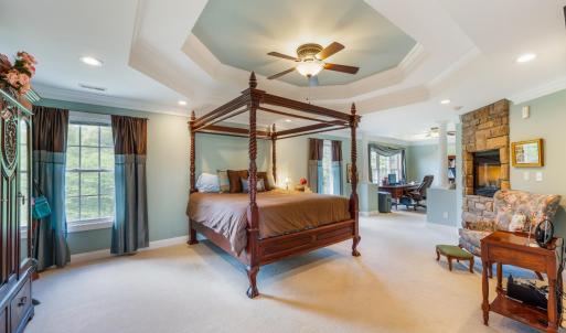 Primary bedroom suite with double tray ceilings, gas fireplace, office space and plenty of light!