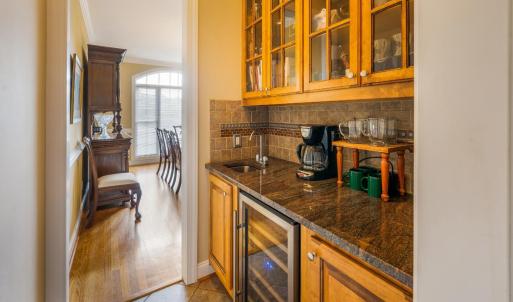 Butlers pantry that passes through from the kitchen to the dining room. Built in wine fridge, custom cabinets, and a bar sink!